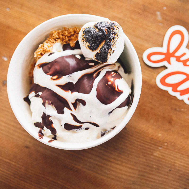 S'Mores Sundae with toppings on a wooden surface next to a 'Julie Ann's' sticker.