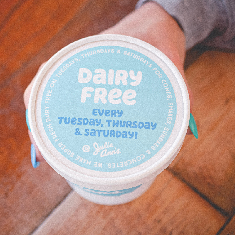 Dairy-free custard pint container on a wooden floor