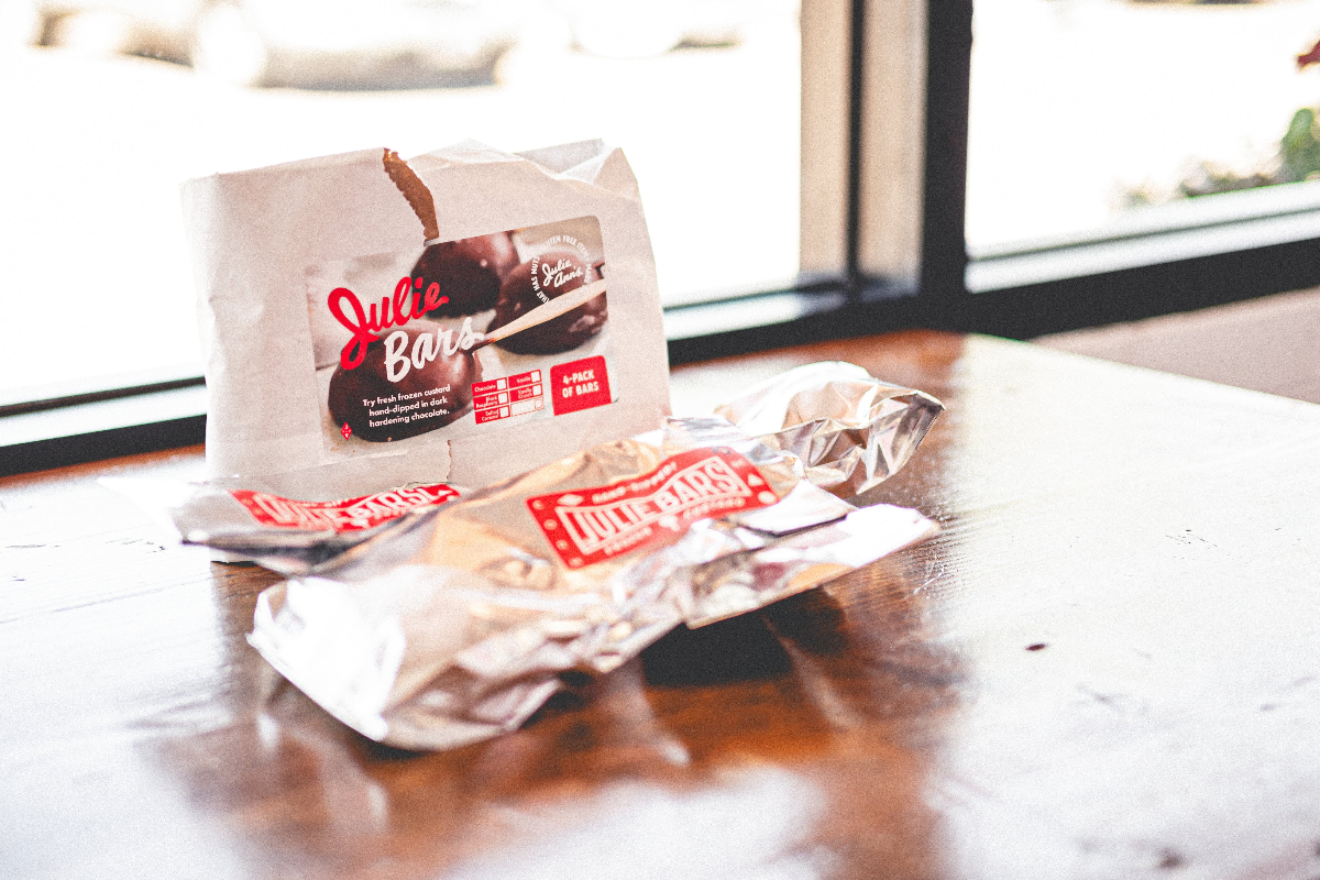 Packages of Julie Bars on a wooden surface with a blurred background