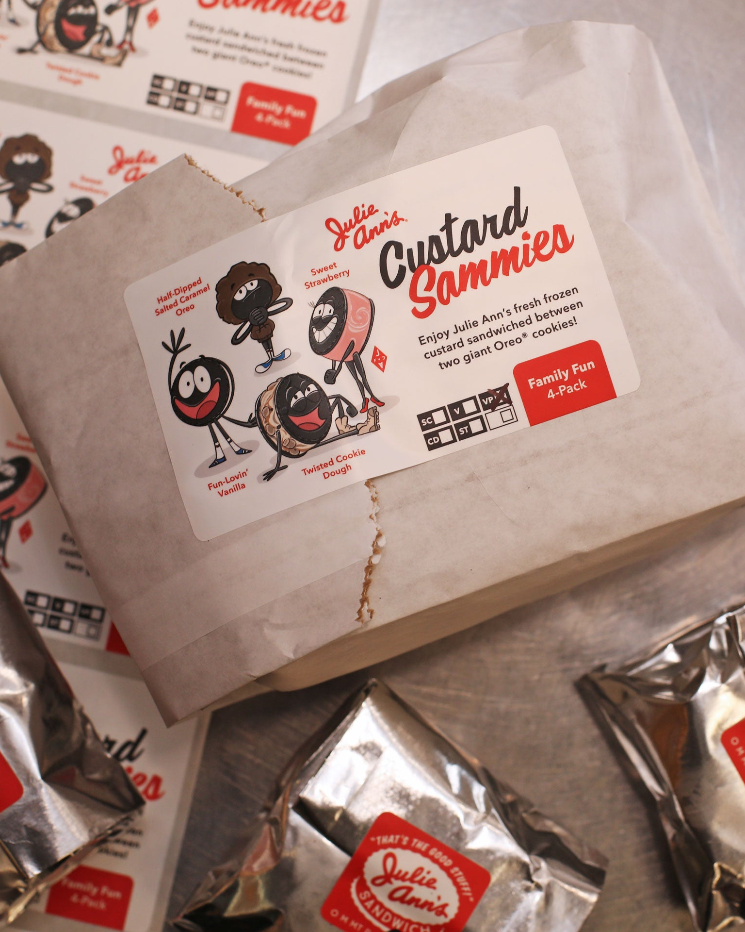 Packages of Custard Sammies with a branded box on a metallic surface